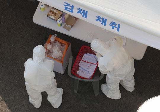 28일 오후 노원구 서울과학기술대학교에 마련된 드라이브 스루 방식의 임시 선별검사소에서 의료진이 검체 채취로 분주한 모습이다.  연합뉴스